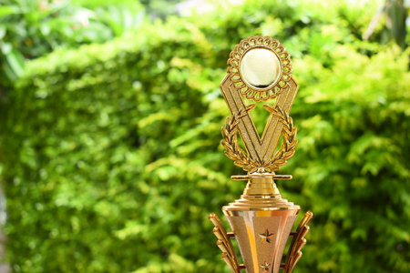 beautiful golden trophy on green tree background