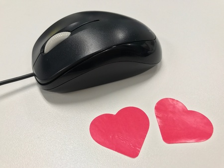 Black computer mouse with pink heart stickersの素材