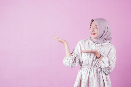 expression of young woman in brown hijab empty space doing hand gesture asking for blank, people promotion concept, isolated on whiteの写真素材