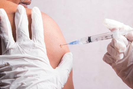 closeup, an old man is injected by a doctor in the upper arm, selective syringe. health concept