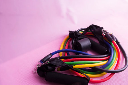 Sports equipment for the gym. Elastic expander, elastic band for fitness.pink backgroundの写真素材