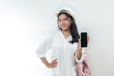 Beautiful young Asian woman tourist in casual white suit preparing for travel and using smartphone...