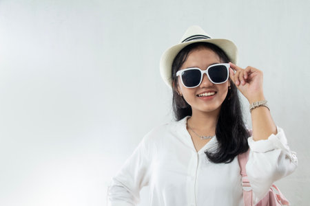 closeup, Young Asian woman wearing straw hat with excited expression and sunglasses running summer vacation, travel advertising studio shootの写真素材