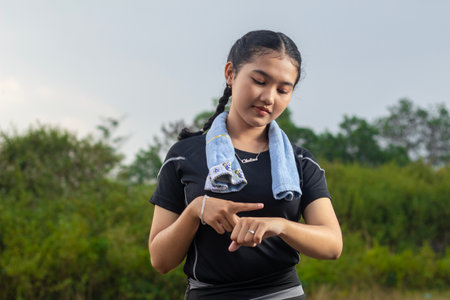 close-up view from below with a beautiful face pointing her hand as if remembering exercise time in the park such as exercise, jogging, running, yoga. she was a woman wearing sportの写真素材