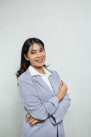 Portrait of a woman with long silky hair standing smiling, looking confident, happy and optimistic, the woman is wearing a blue suit and white top isolated on whiteの写真素材