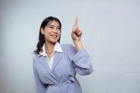 beautiful young office girl candid and pointing forward while smiling at the camera, woman in light purple blue shirt suit isolated on whiteの写真素材