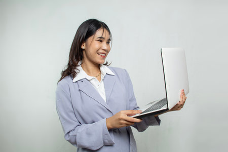 closeup concept photo of a beautiful female office worker carrying a laptop to check work, the woman...