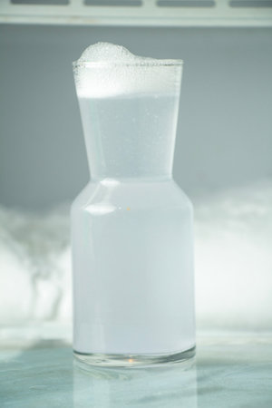 A single white cocktail in a jug is white and frothy, portraitの写真素材