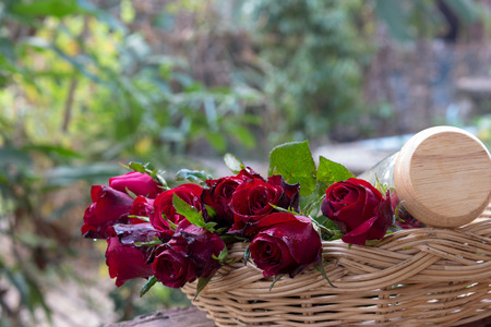 Roses and glass in basketの写真素材