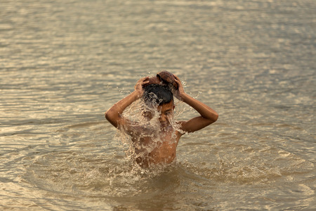 Children playing in water in the Mekong River baler Thailand is the life of a boy in the Mekong River Basin. Time to go fishing with his father.の写真素材