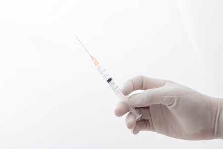 hands holding syringe closeup on white backgroundの写真素材