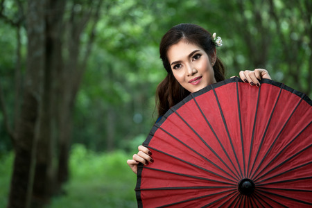 beautiful smiling girl with red umbrellaの写真素材