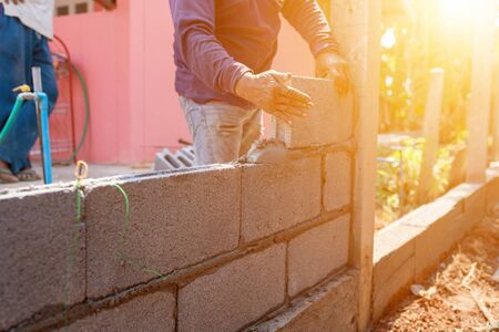 Masoners constructing masonry to build fencesの写真素材