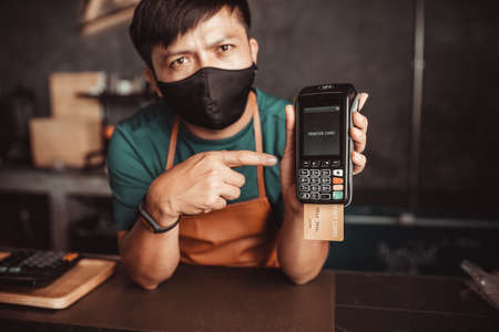 The cashier recommends paying with a credit card machine.の写真素材