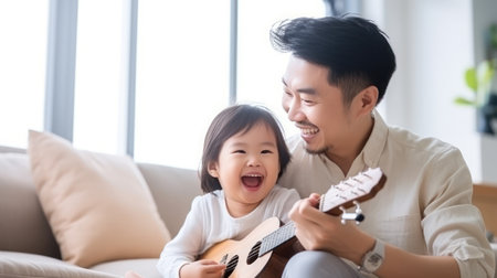 a child playing ukulele in the living room with father so happyの素材