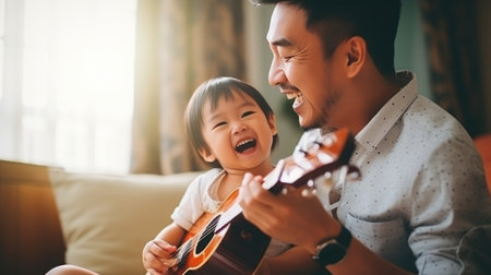 a child playing ukulele in the living room with father so happyの素材