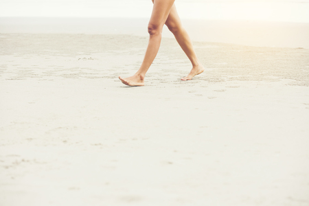 Woman walking on white sand beach in thailandの写真素材