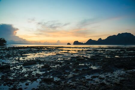 beautyful majestic blue sky sunrise at beach with mountains landscape and treeの写真素材