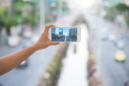 Taking a photo of a city tower in bangkok, Taking photo with smartphoneの写真素材