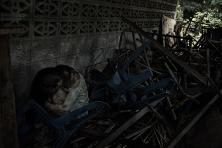 zombie woman sitting hold in knee with many chair low light for Halloween festivalの写真素材