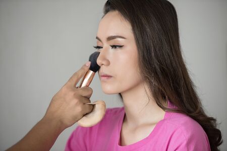 Makeup artist at work. makeup asia woman in pink shirt fashion modelの写真素材