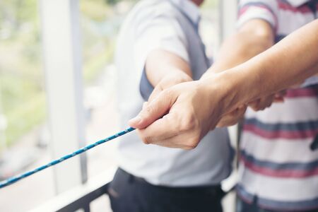 Hands of people pulling the rope cooperation concept. business team using a rope as an element of the teamwork.の写真素材