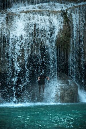 Blured man jumping to water at waterfall Kanchanaburi, Thailandの写真素材