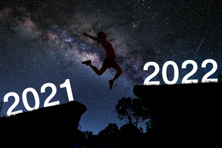 Sport woman jump on mountain on night sky milky way background. Female jump 2021 to 2022 happy new...