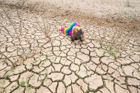 woman portrait in dryland with drought ground texture. concept climate changed.の写真素材