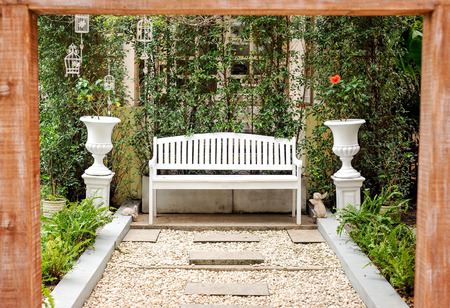 white bench in the garden on a sunny dayの写真素材