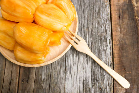 Fresh jack fruit on wooden plate with fork. On old wood background.の写真素材