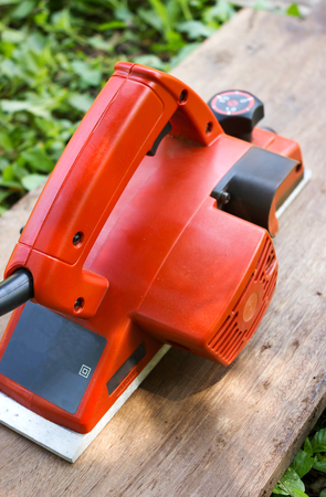 Closeup electric wood plane with green background.の写真素材