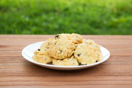 Butter cookies with raisin and almond. On wooden table with green background.の写真素材