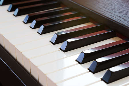 Closeup piano keyboard. Sunlight through in a part of keyboard.の写真素材