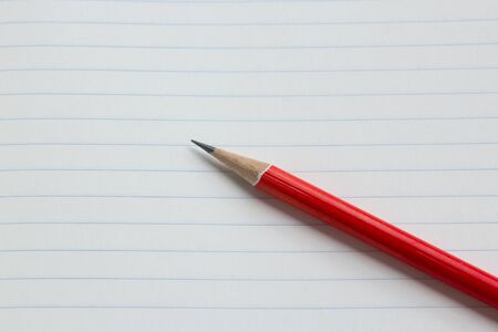 Red pencil on green read paper.の写真素材