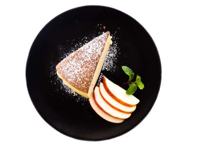 Japanese cheesecake on black plate. Served with icing topping and apple sliced. Sweet taste with softness and moist taste touch. Top view over white isolate background.の写真素材