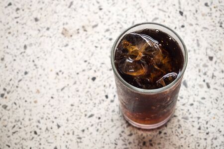 Black soft drink with ice cube in glass. Favorite soft drink for refreshment. Top view with copy space.の写真素材