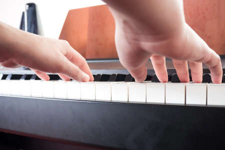 Closeup woman hands playing piano. Music and art background. Favorite classical instrument. Lower...