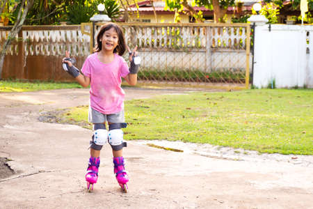 Smiling Asian girl playing rollerblading at home. Leisure sport background. Happiness moment.の写真素材