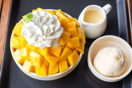 Shaved ice dessert served with mango sliced,  whipped cream and vanilla ice cream. Sweet dessert in Korean style. Local name, Bingsu.の写真素材