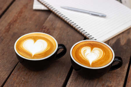 Couple hot coffee with latte art in heart shape. Concept of take relax with favorite caffeine beverage and people of love. Refreshment drink in morning.の写真素材