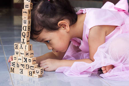 Asian little girl concentrate for building wooden block. Concept of play and learn.の写真素材