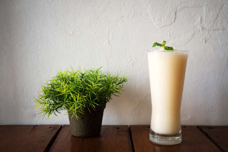 Glass of melon smoothie on wooden table. Healthy beverage and freshness drink. Summer fruit. Food and drink background.の写真素材
