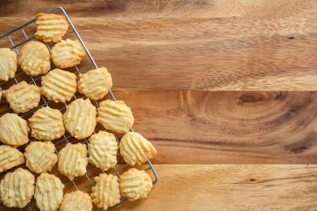 Homemade butter cookies on baking rag. Sweet dessert. Top view on wooden background with copy space.