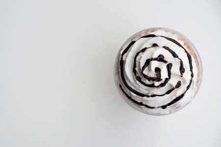 Top view of whipping cream on mocha frappe in plastic cup. Beverage background with copy space....