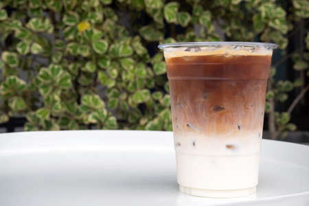 Glass of ice latte in plastic cup. Easy pagage of most useful. Favorite menu for caffeine lover with...