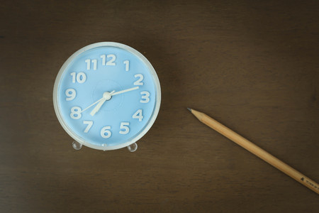 Vintage background with alarm clock on a tableの写真素材