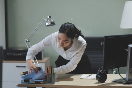 Modern Office Businessman Working on Computer. Portrait of Successful Latin IT Software Engineer Working on a Laptop at his Desk. Diverse Workplace with Professionals. Front View Shotの写真素材