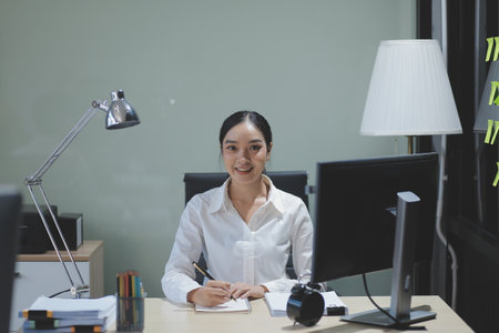 Modern Office Businessman Working on Computer. Portrait of Successful Latin IT Software Engineer Working on a Laptop at his Desk. Diverse Workplace with Professionals. Front View Shotの写真素材