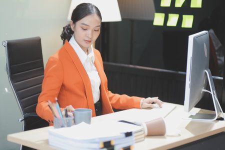 Young adorable Asian businesswoman working with work document during the night, working overtime at night.の写真素材